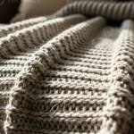 Warm beige chunky knit blanket close up - soft chenille texture